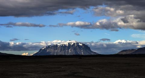 Herðubreið, bjart yfir en þung ský blandast við bláan himininn
